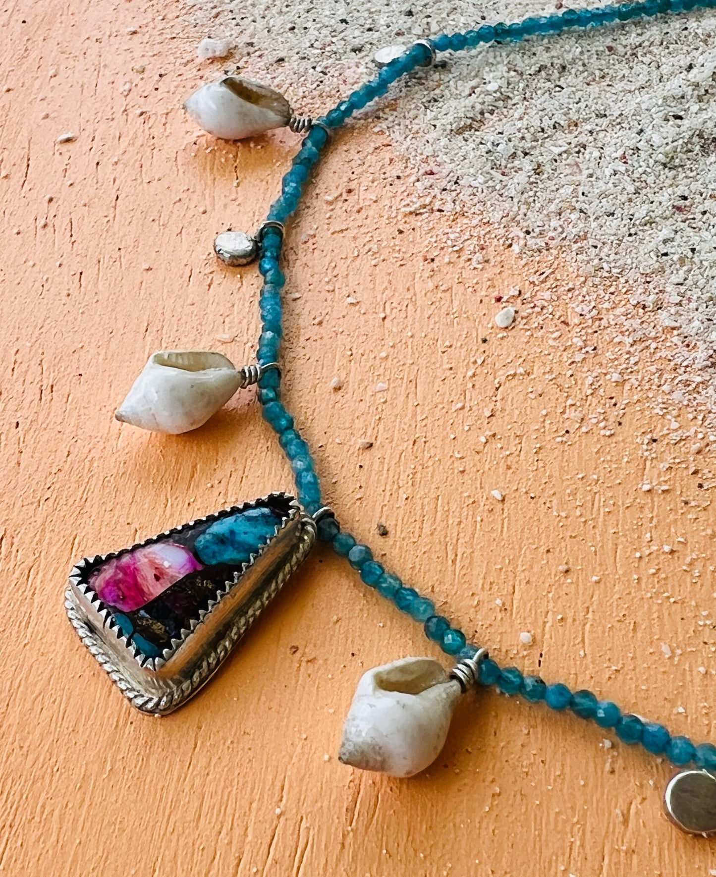 Necklace with shell pendants on a textured surface