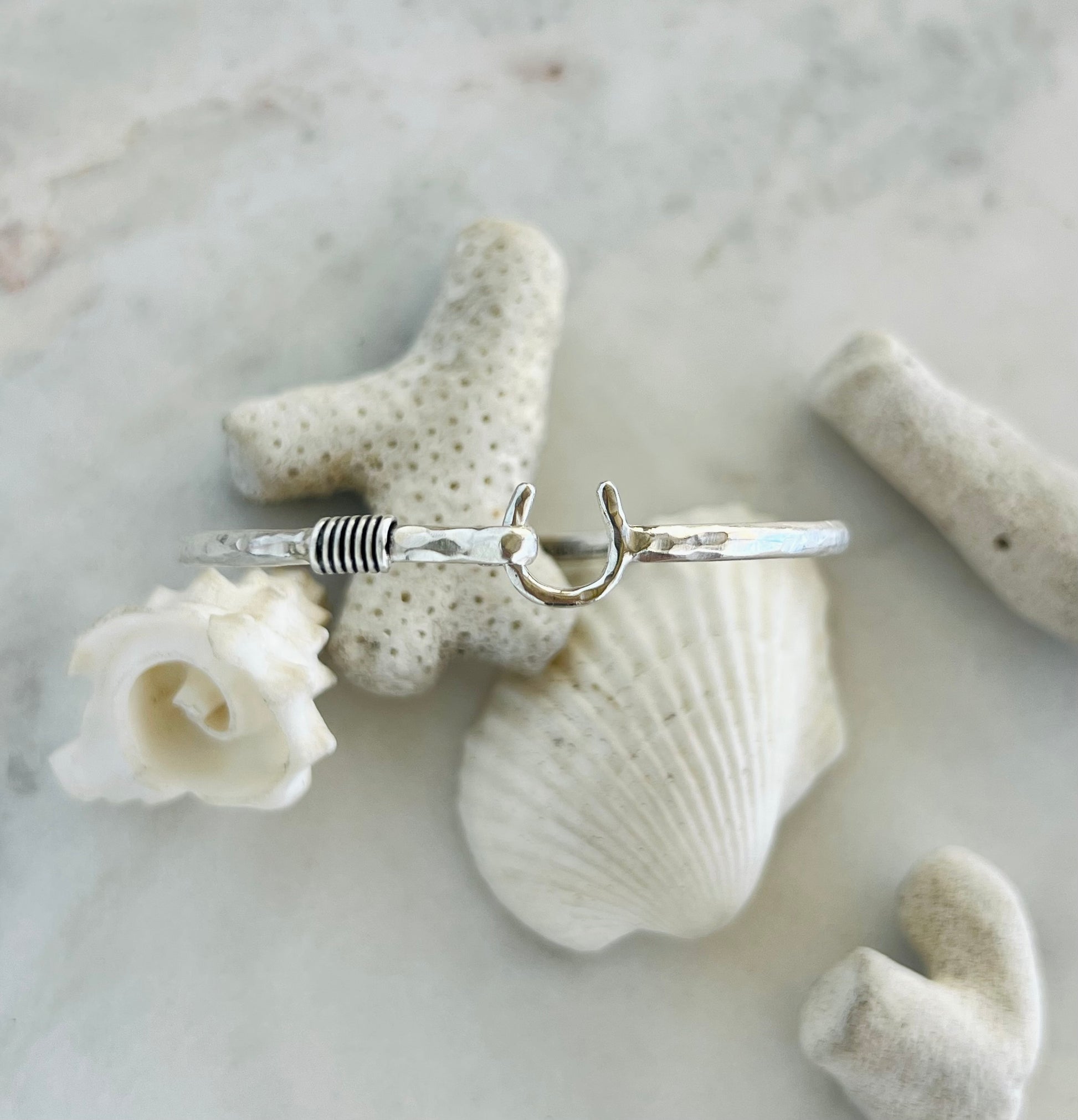 Silver ring on a white shell and coral