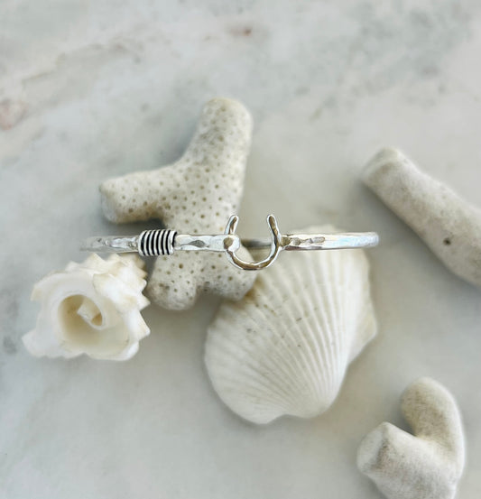 Silver ring on a white shell and coral