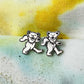 Pair of dancing bear earrings on a textured fabric background