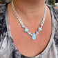 Necklace with blue stones and silver chain worn by a person