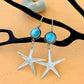 Silver starfish earrings with blue gemstones on a beige background