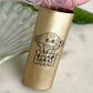 Gold tumbler with a mushroom design and text on a marble surface