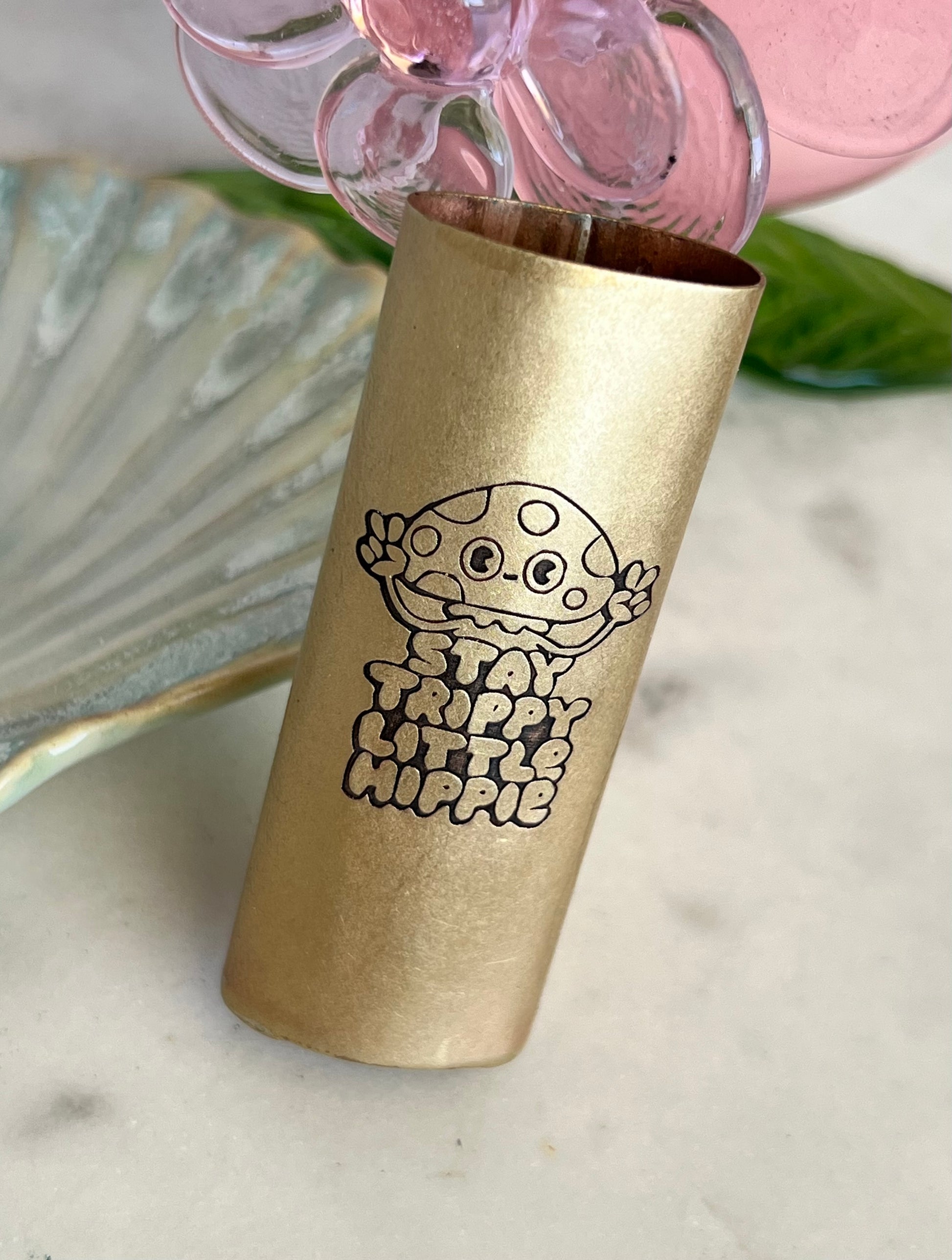 Gold tumbler with a mushroom design and text on a marble surface