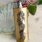 Bronze lighter with mermaid design on a light background