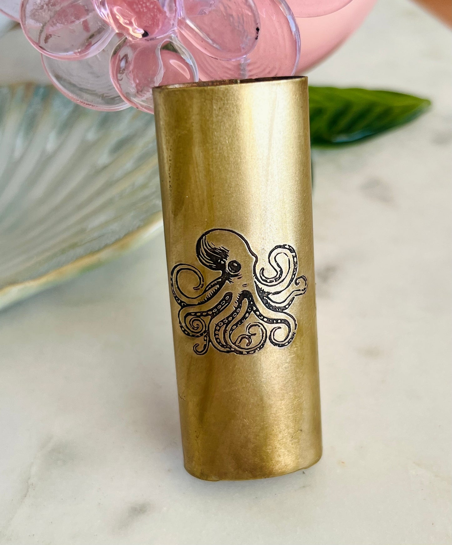 Brass tumbler with octopus design on a marble surface