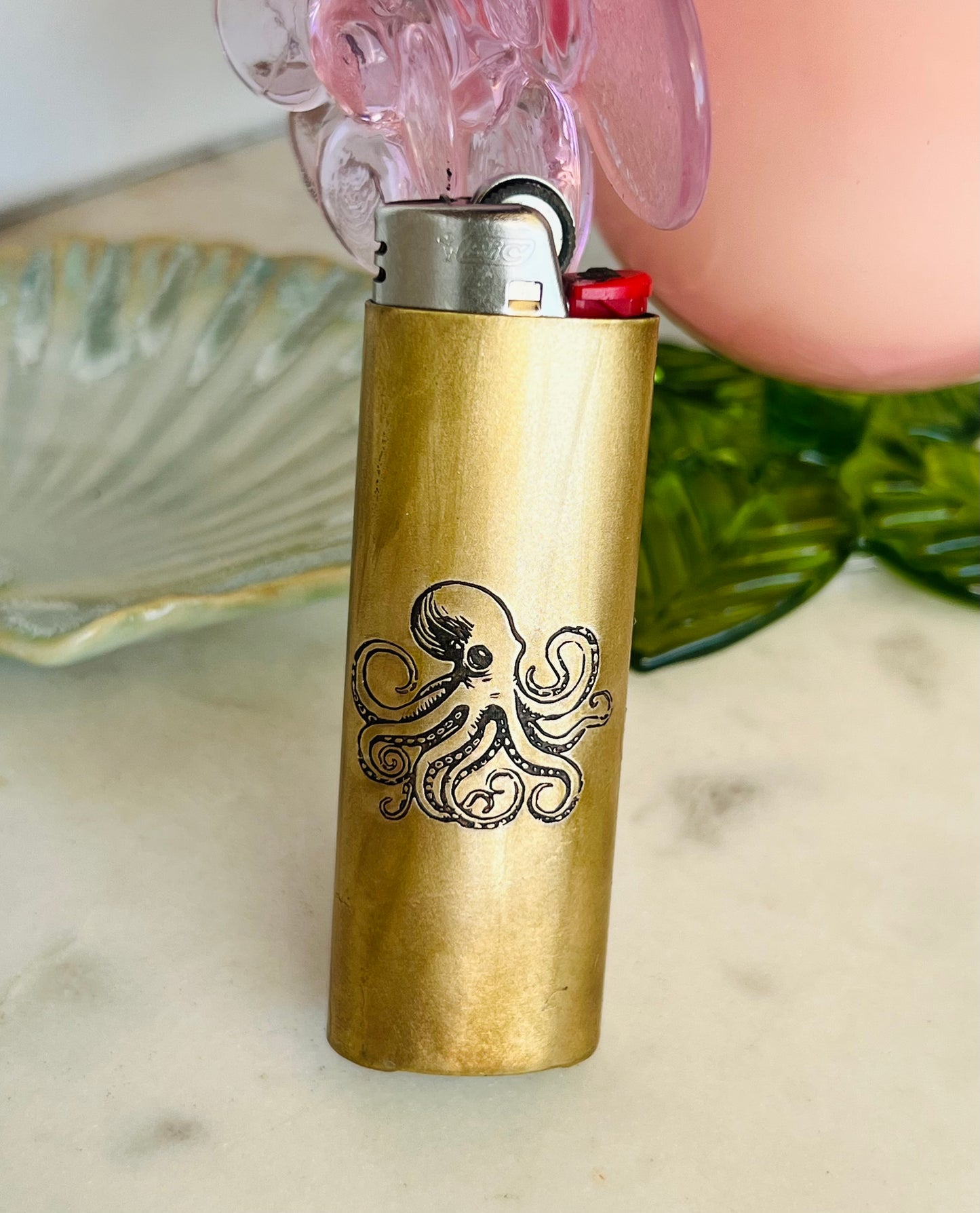 Brass lighter with octopus design on a marble surface