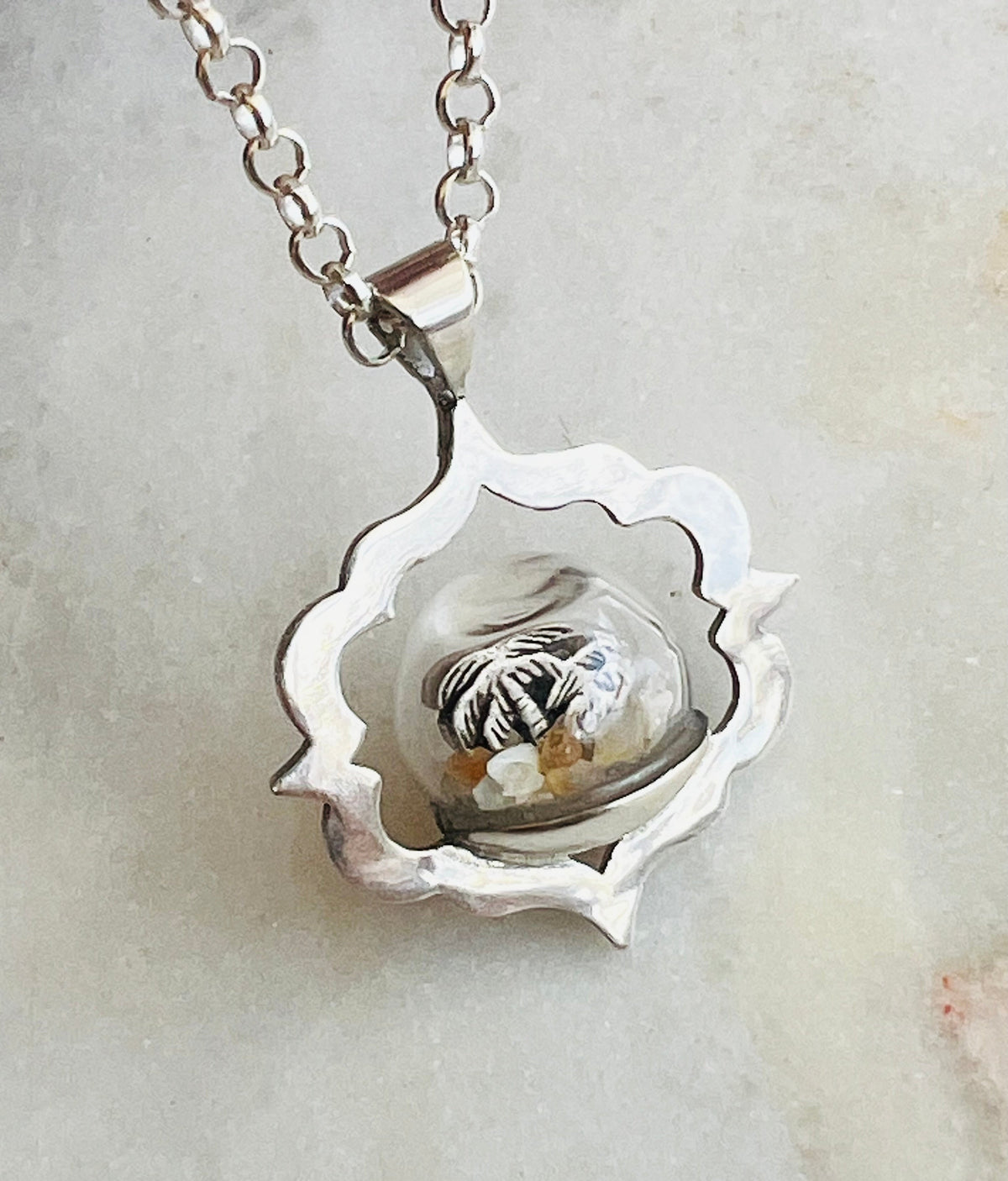 Close up of front of Palm Tree Beach Globe Necklace.