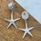 Silver starfish-shaped earrings on a wooden surface