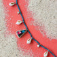 Necklace with shell pendants on a sandy surface