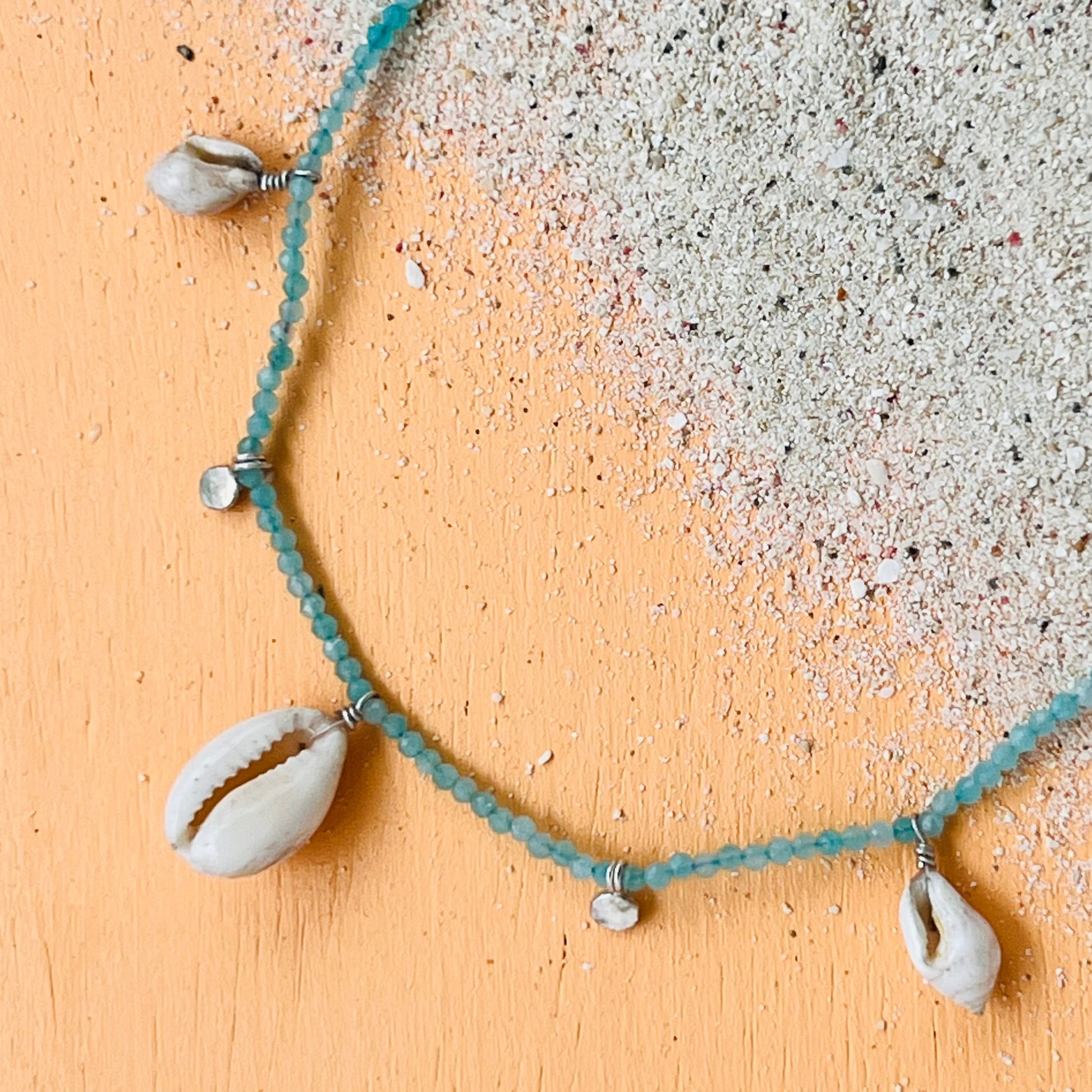Necklace with seashell pendants on a textured surface